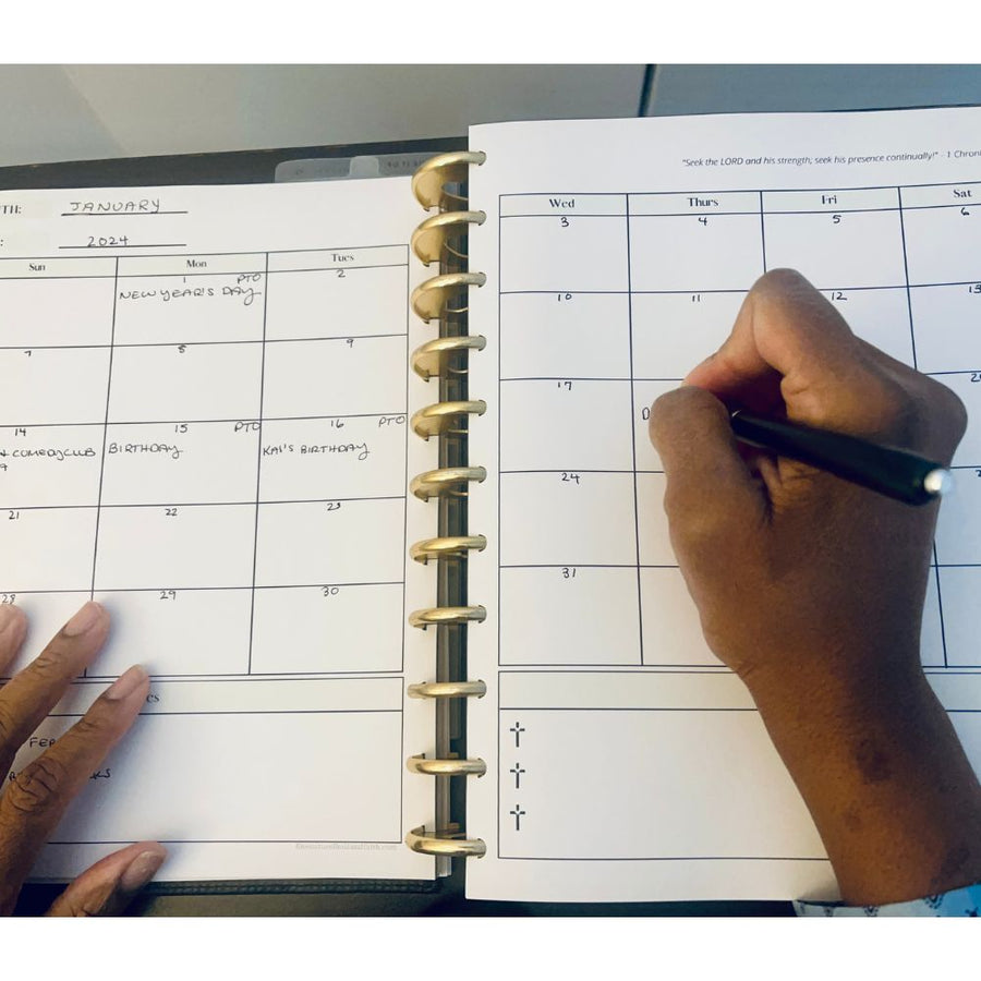 woman writing in printable christian planner's monthly spread